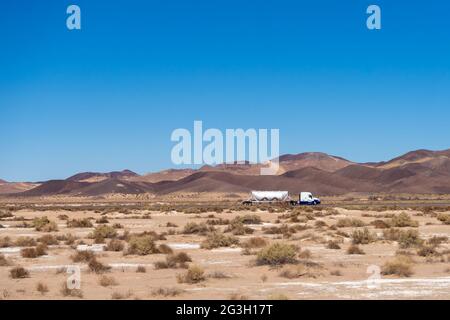 Newberry Springs, CA, USA – February 18, 2021: Semi truck with a dry bulk trailer traveling on Interstates 40 in the Mojave Desert near Newberry Sprin Stock Photo