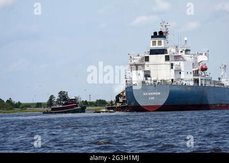 tug boats guiding large ship; assistance, Greece registry; work boats; transportation, marine, boat, industry, shoreline, ICW, Intracoastal Waterway, Stock Photo