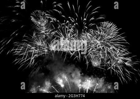 Sparkling white fireworks display in a black sky. Black and white photograph. Stock Photo