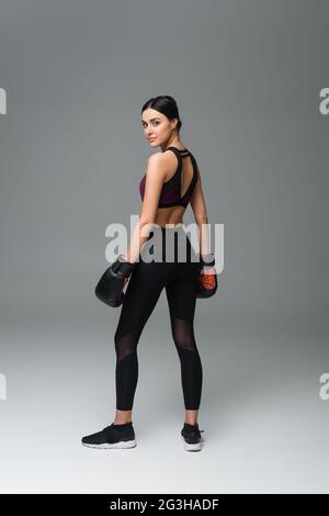 Woman in black sports bra and black leggings wearing black boxing