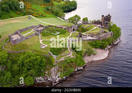 Urquhart Castle, Loch Ness, Scotland, UK. 12 June 2021. Pictured: Drone aerial photography view from above of Urquhart Castle, a ruin, sits beside Loch Ness in the Highlands of Scotland. The castle is on the A82 road, 21 kilometres south-west of Inverness and 2 kilometres east of the village of Drumnadrochit. Credit: Colin Fisher/Alamy Live News. Stock Photo