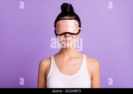 Photo portrait of woman wearing pretty pink sleeping mask smiling isolated on pastel purple color background Stock Photo