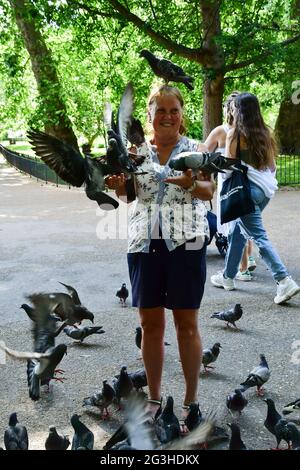 Hyde Park, London, UK. 16th June, 2021. Hyde Park, London, UK. 16th June, 2021. People feeding birds Parakeets and pigeon at Hyde park on 16th June 2021, London, UK Credit: Picture Capital/Alamy Live News