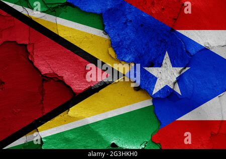 flags of Guyana and Puerto Rico painted on cracked wall Stock Photo