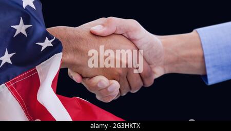 Composition of hands of two diverse people shaking hands and american flag on black Stock Photo