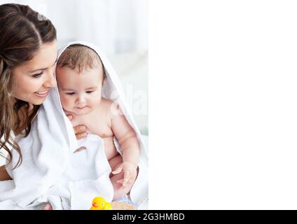 Composition of smiling mother holding baby wrapped in blanket Stock Photo