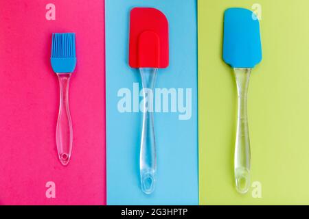 Silicone kitchen utensils on a tricolor background Stock Photo