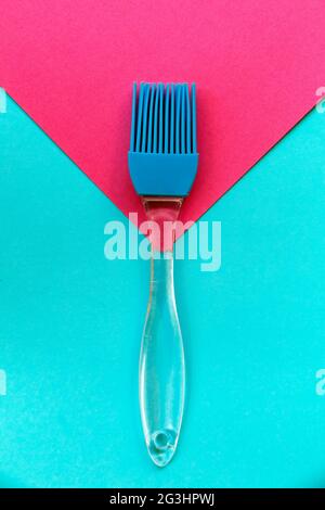 Cooking utensil. Silicone brush on blue and pink geometric background Stock Photo