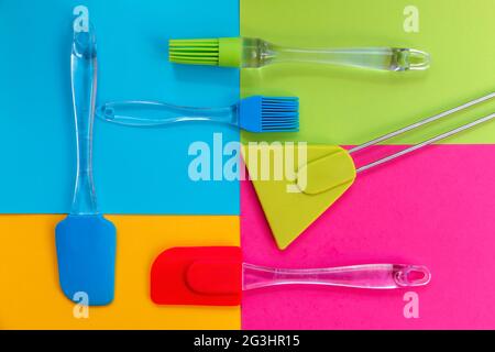Cooking utensils. Spatulas and silicone brushes on bright colored geometric background Stock Photo