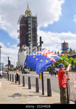 London, UK. 16th June, 2021. A protester waves a combined Union Jack and European Union flag outside the Houses of Parliament during a small anti-Brexit and anti-Tory government demonstration in London. Credit: SOPA Images Limited/Alamy Live News Stock Photo