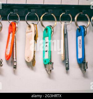 The keys to the doors with tags hang on hooks in a special drawer. Selective focus Stock Photo