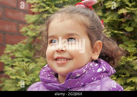 portrait of a smiling little girl wearing a jacket Stock Photo