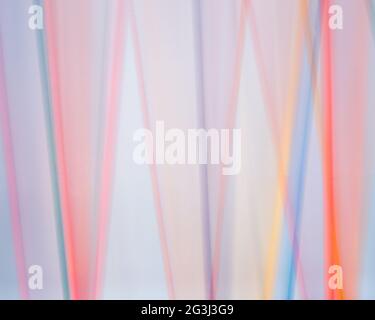 Colored dowels blurred against a white background in a time lapse photo. Stock Photo