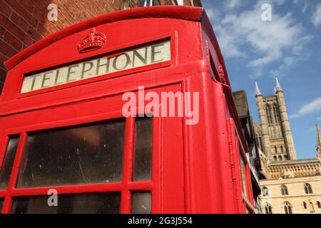 Traditional red British phone box and the early gothic 11th century Lincoln Cathedral (Lincoln Minster or St Mary's Cathedral), Bailgate, Lincoln, UK. Stock Photo