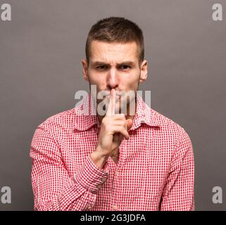 man shushing with hand gesture Stock Photo - Alamy