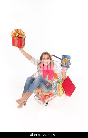 Happy woman in shopping cart with presents Stock Photo