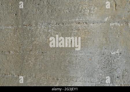 The uneven surface of an old concrete wall with splashes of crushed stone . Texture, background. Stock Photo