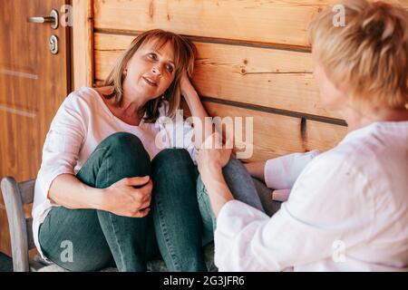 Cozy company of two girlfriends 55 years old, spending time having ? nice conversation Stock Photo