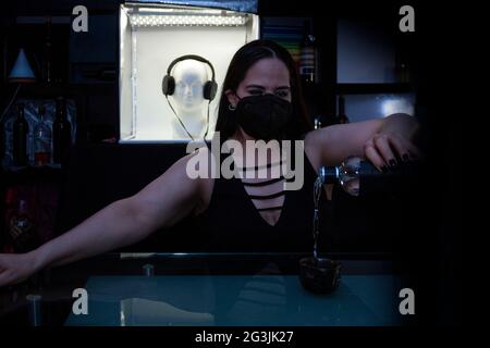 Waitress doing her job serves a mezcal in the counter of a bar nightlife Mexico City Stock Photo