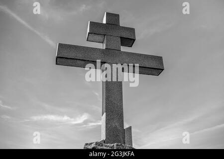 Ancient cross against a blue sky in the city of Pskov, Russia. Black and white. Stock Photo