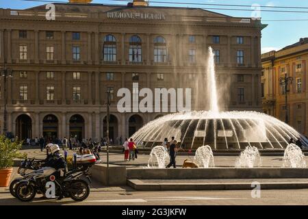 View of Piazza De Ferrari, Genoa's main square, with the bubbling fountain, motorcycle policemen and the Palace of the Ligurian Region, Liguria, Italy Stock Photo