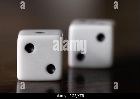 Two Dice on a Wood Table with Two Showing Stock Photo
