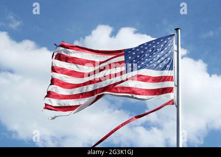 American flag flying against a blue sky Stock Photo