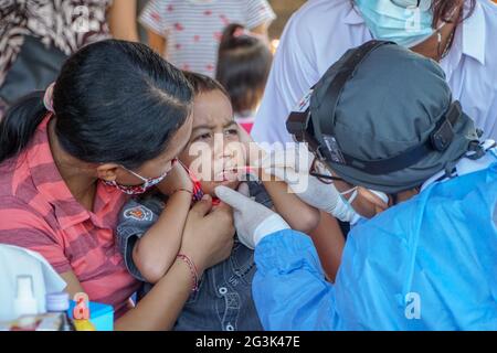 BALI/INDONESIA-MAY 28 2021: An ENT doctor is examining the ears, nose and throat of a pediatric patient. During the COVID-19 pandemic, ENT examination Stock Photo