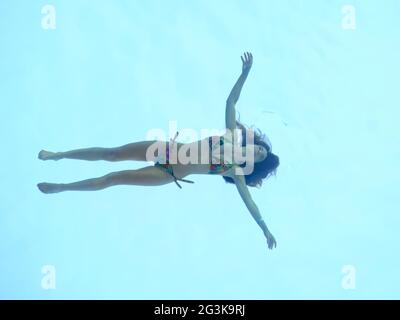 A swimmer glides through the water in the transparent Sky Pool at Embassy Gardens. Suspended between two buildings it is said to be the world's first. Stock Photo