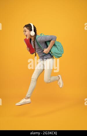 Chase your dream. Energetic kid hurry to school. Happy child in energetic jump yellow background. Energetic mood. Healthy and energetic. School Stock Photo