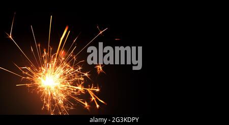 A burning sparkler on black
