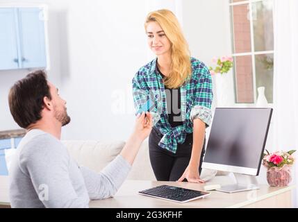 Man giving credit card to woman Stock Photo