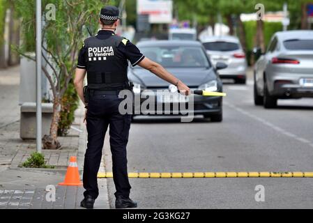 Vendrell, Spain. 16th June, 2021. A local police officer pulls-over a vehicle during a police control at a checkpoint.The Local Police of Vendrell Spain, carries out random traffic police controls to ensure compliance with the law. They carry out alcohol and drug controls on drivers and that the vehicles comply with the rules such as technical inspection every 4 years and accident insurance, according to Spanish traffic laws. Credit: SOPA Images Limited/Alamy Live News Stock Photo