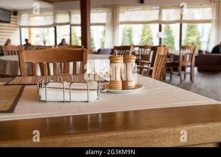 Part of restaurant table setting salt, pepper, toothpicks and paper napkins in wooden box on table Stock Photo