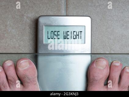 Man's feet on weight scale - Lose weight Stock Photo