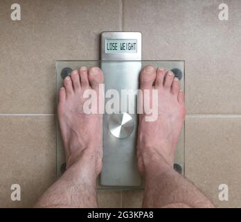 Man's feet on weight scale - Lose weight Stock Photo