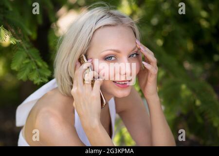 Young blond female having phone conversation. Stock Photo