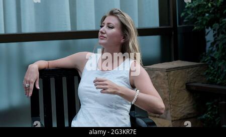 Eastern European Caucasian woman middle aged blonde hair light skin pale complexion in white dress outside summer time casual Stock Photo