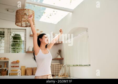 Woman stretches herself sitting at the kitchen Stock Photo