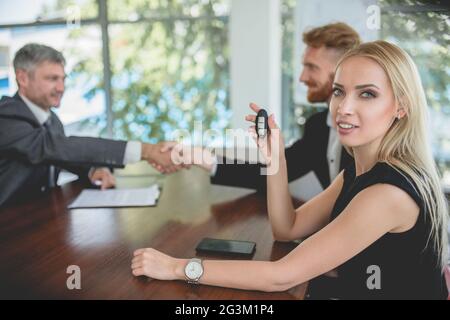 Happy young woman holding key from new car. Stock Photo