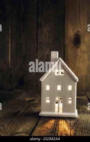 White house shaped ceramics candle holder on wooden background Stock Photo