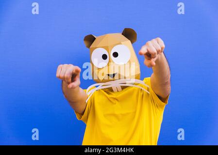 Cool man wearing 3d origami mask with stylish colored clothes - Creative concept for advertising, animal head mask doing funny things on colorful back Stock Photo