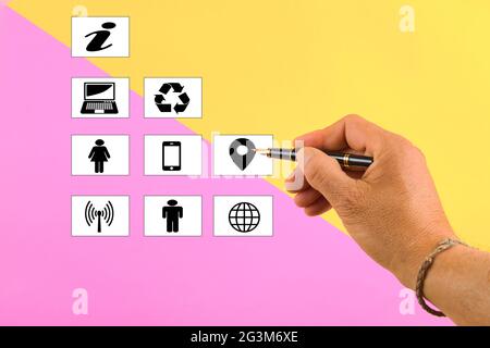 hand holding a pen writing a shapes of a different concepts on a pink and yellow background Stock Photo