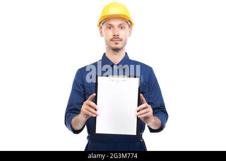 Horizontal medium portrait of successful handsome young adult Caucasian construction engineer wearing uniform holding clipboard with papers Stock Photo