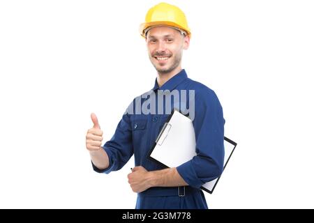 Horizontal medium portrait of successful handsome young adult Caucasian construction engineer wearing uniform holding clipboard with papers Stock Photo