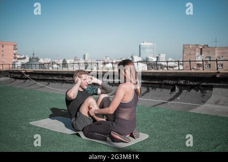 Man doing abdominal situps on the roof. Stock Photo