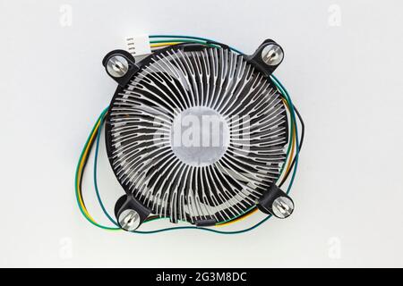Heatsink fan of a microprocessor on a white background. It has yellow, black, blue and green colored cables and a connector for the motherboard. Stock Photo