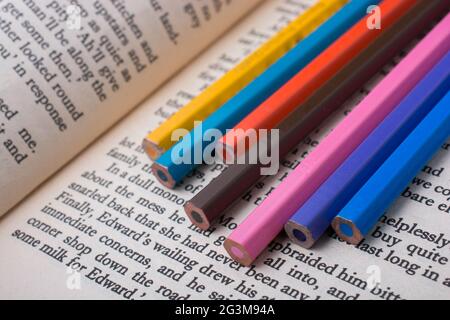 Color pencils placed on the page of a book Stock Photo