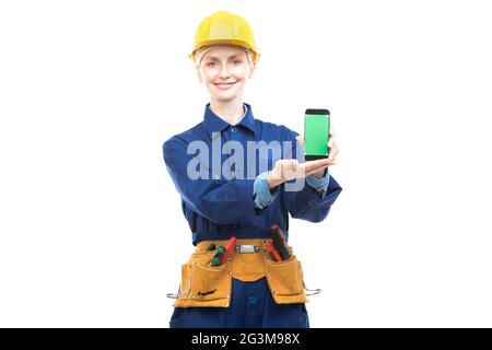Horizontal medium portrait of modern professional female construction worker wearing blue uniform demonstrating mobile app on smartphone screen Stock Photo