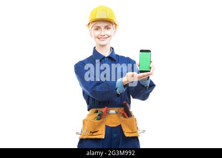 Horizontal medium portrait of modern professional female construction worker wearing blue uniform demonstrating mobile app on smartphone screen Stock Photo